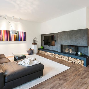 Mittelgroßes, Offenes Modernes Wohnzimmer mit weißer Wandfarbe, braunem Holzboden, Tunnelkamin, Wand-TV und braunem Boden in Hamburg