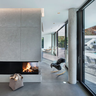 Geräumiges, Repräsentatives, Fernseherloses Modernes Wohnzimmer im Loft-Stil mit weißer Wandfarbe, Linoleum, Tunnelkamin, Kaminumrandung aus Beton und grauem Boden in München