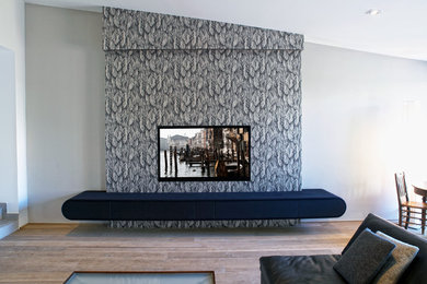 Modelo de salón abierto contemporáneo con paredes blancas y televisor colgado en la pared