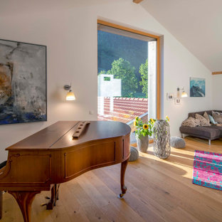 Country Wohnzimmer mit weißer Wandfarbe, braunem Holzboden, braunem Boden und gewölbter Decke in München