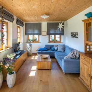 Country Wohnzimmer mit weißer Wandfarbe, braunem Holzboden, braunem Boden und Holzdecke in München