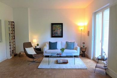 Mittelgroßes, Abgetrenntes Modernes Wohnzimmer ohne Kamin mit weißer Wandfarbe, braunem Holzboden und beigem Boden