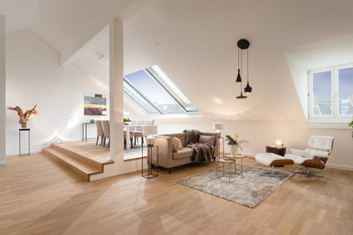 Modelo de sala de estar actual grande con paredes blancas, suelo de madera en tonos medios y suelo marrón