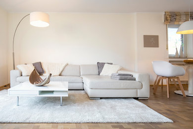 Mittelgroßes, Offenes Modernes Wohnzimmer mit gelber Wandfarbe, braunem Holzboden und braunem Boden in Düsseldorf