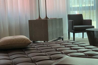 Modernes Wohnzimmer mit grauer Wandfarbe, hellem Holzboden und braunem Boden in München