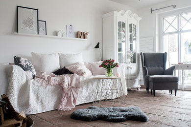 Esempio di un soggiorno shabby-chic style con pareti bianche, pavimento in terracotta, nessun camino, nessuna TV e tappeto