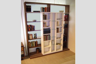 Foto di un soggiorno minimal di medie dimensioni e chiuso con libreria, pareti bianche, parquet chiaro e pavimento marrone