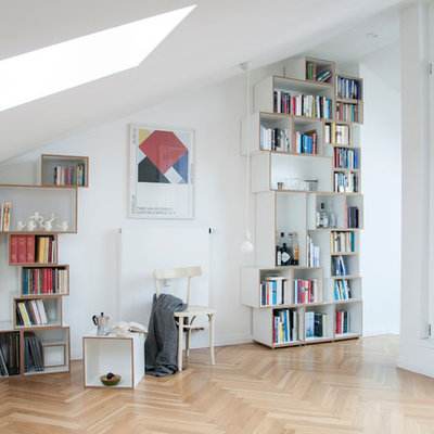 Mid-sized danish enclosed medium tone wood floor and brown floor family room library photo in Berlin with white walls, no fireplace and no tv
