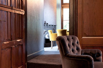 Foto de salón para visitas abierto clásico grande con paredes grises, suelo de madera en tonos medios, suelo marrón, boiserie y estufa de leña