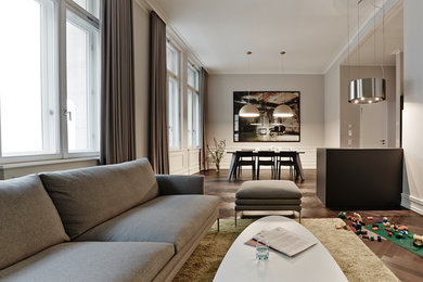 Großes, Offenes, Fernseherloses Modernes Wohnzimmer ohne Kamin mit grauer Wandfarbe, braunem Holzboden und braunem Boden in Berlin
