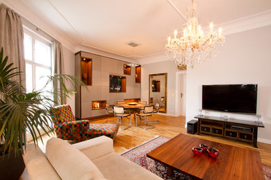 Großes, Offenes Eklektisches Wohnzimmer ohne Kamin mit grauer Wandfarbe, braunem Holzboden und TV-Wand in Berlin