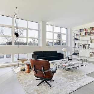 Große, Fernseherlose, Offene Moderne Bibliothek ohne Kamin mit weißer Wandfarbe, Betonboden und grauem Boden in Köln