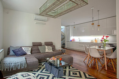 Mittelgroßes, Offenes Modernes Wohnzimmer mit braunem Holzboden und weißer Wandfarbe in München