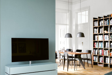 フランクフルトにある中くらいなコンテンポラリースタイルのおしゃれなLDK (ライブラリー、白い壁、塗装フローリング、暖炉なし、据え置き型テレビ、ベージュの床) の写真