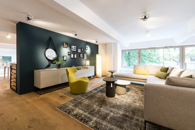 Großes, Offenes Modernes Wohnzimmer ohne Kamin mit braunem Holzboden und braunem Boden in Berlin