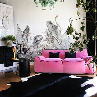 Kleines, Fernseherloses, Abgetrenntes Modernes Wohnzimmer mit grauer Wandfarbe, braunem Holzboden, Kamin, gefliester Kaminumrandung und braunem Boden in Hamburg