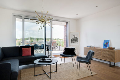 Großes, Offenes Modernes Wohnzimmer mit weißer Wandfarbe, gebeiztem Holzboden, Kaminofen, verputzter Kaminumrandung und braunem Boden in Düsseldorf