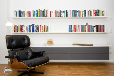 Mittelgroße, Fernseherlose, Offene Moderne Bibliothek ohne Kamin mit weißer Wandfarbe, braunem Holzboden und braunem Boden in Hamburg