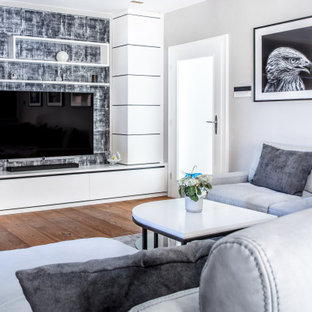 Mittelgroßes Modernes Wohnzimmer mit grauer Wandfarbe, braunem Holzboden, Wand-TV, braunem Boden und Tapetenwänden in Berlin