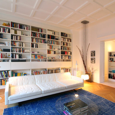 Family room library - large scandinavian enclosed medium tone wood floor family room library idea in Berlin with white walls, no tv and no fireplace
