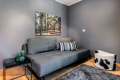 Kleines, Fernseherloses, Abgetrenntes Modernes Wohnzimmer ohne Kamin mit grauer Wandfarbe, hellem Holzboden und braunem Boden in München
