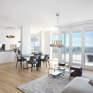 Großes, Repräsentatives, Fernseherloses Modernes Wohnzimmer ohne Kamin, im Loft-Stil mit weißer Wandfarbe, braunem Holzboden und braunem Boden in Frankfurt am Main