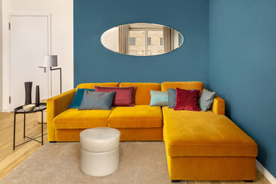 Eklektisches Wohnzimmer mit blauer Wandfarbe und hellem Holzboden in Berlin