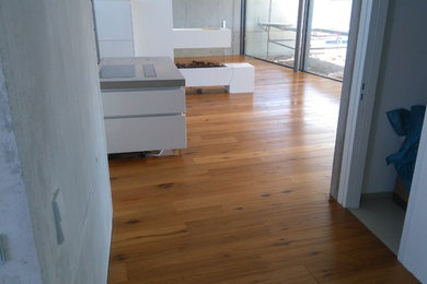 Modernes Wohnzimmer mit braunem Holzboden und Kamin in Stuttgart