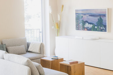 Kleines, Offenes Modernes Wohnzimmer mit beiger Wandfarbe, braunem Holzboden, verstecktem TV und braunem Boden in Frankfurt am Main