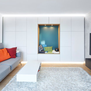 Abgetrennte, Große Moderne Bibliothek ohne Kamin mit weißer Wandfarbe, Wand-TV, braunem Boden und hellem Holzboden in Stuttgart