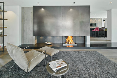 Geräumiges, Offenes Modernes Wohnzimmer mit weißer Wandfarbe, braunem Holzboden, Kaminofen, Kaminumrandung aus Metall und braunem Boden in München