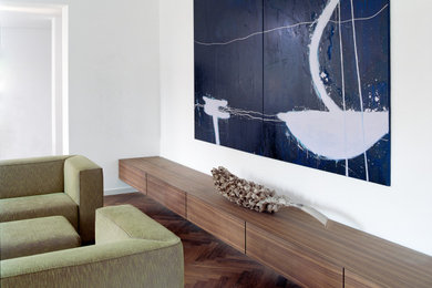 Geräumiges, Repräsentatives Modernes Wohnzimmer mit weißer Wandfarbe, braunem Holzboden, Kaminumrandung aus Metall und braunem Boden in Köln