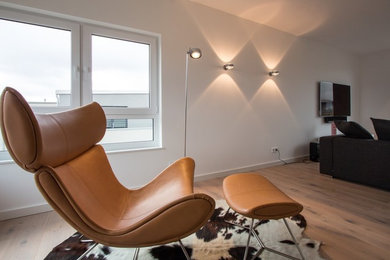 Repräsentatives Modernes Wohnzimmer mit weißer Wandfarbe, hellem Holzboden, TV-Wand und braunem Boden in Hamburg