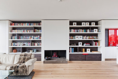 Ispirazione per un grande soggiorno contemporaneo stile loft con libreria, pareti bianche, parquet chiaro, camino classico e TV autoportante