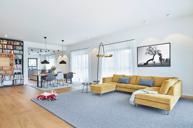 Geräumiges, Offenes Modernes Wohnzimmer in grau-weiß mit weißer Wandfarbe, braunem Holzboden, Eckkamin, TV-Wand und beigem Boden in Frankfurt am Main
