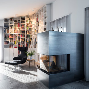 Moderne Bibliothek mit weißer Wandfarbe, Kamin und grauem Boden in Nürnberg