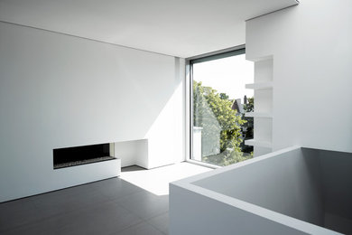 Großes Modernes Wohnzimmer im Loft-Stil mit weißer Wandfarbe, Keramikboden, verstecktem TV, Gaskamin und verputzter Kaminumrandung in Leipzig