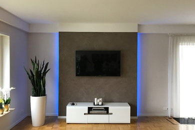 Mittelgroßes, Offenes Modernes Wohnzimmer mit beiger Wandfarbe, hellem Holzboden und Multimediawand in Sonstige