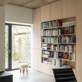 Offene, Mittelgroße, Fernseherlose Moderne Bibliothek mit weißer Wandfarbe, Betonboden und grauem Boden in Berlin