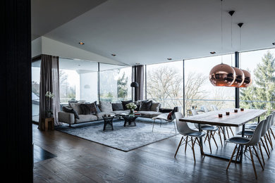 Example of a huge trendy open concept dark wood floor family room design in Munich with no tv and white walls