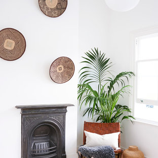 Design ideas for a medium sized scandinavian enclosed living room in London with white walls, light hardwood flooring, no tv, brown floors, a wood burning stove and a metal fireplace surround.