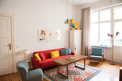 Mittelgroßes Eklektisches Wohnzimmer mit weißer Wandfarbe und braunem Holzboden in Berlin