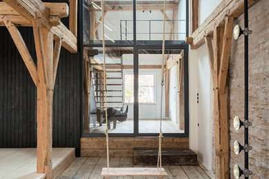Rustikales Wohnzimmer ohne Kamin, im Loft-Stil mit beiger Wandfarbe, dunklem Holzboden, braunem Boden und Steinwänden in München