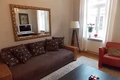 Mittelgroßes, Abgetrenntes Klassisches Wohnzimmer mit beiger Wandfarbe, gebeiztem Holzboden, freistehendem TV und braunem Boden in Nürnberg