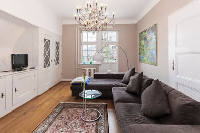Esempio di un soggiorno classico di medie dimensioni e chiuso con pareti beige, pavimento in legno massello medio e pavimento marrone