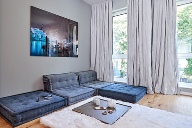 Mittelgroßes, Abgetrenntes, Repräsentatives, Fernseherloses Modernes Wohnzimmer ohne Kamin mit grauer Wandfarbe, braunem Holzboden und braunem Boden in Hamburg