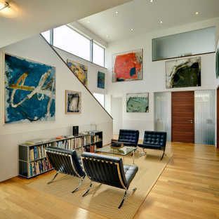 Kleines, Repräsentatives, Fernseherloses, Offenes Modernes Wohnzimmer ohne Kamin mit weißer Wandfarbe, braunem Holzboden und braunem Boden in München