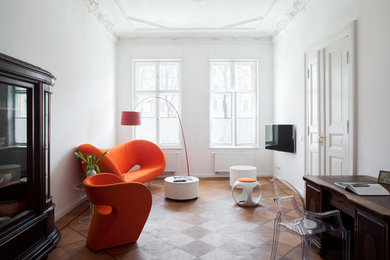 Abgetrenntes Eklektisches Wohnzimmer ohne Kamin mit weißer Wandfarbe, braunem Holzboden und TV-Wand in Berlin