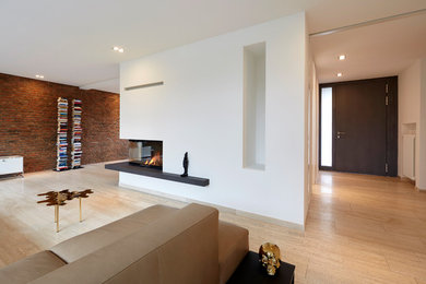 Foto de salón abierto contemporáneo de tamaño medio con paredes blancas, suelo de travertino, chimenea de esquina, marco de chimenea de yeso y suelo beige