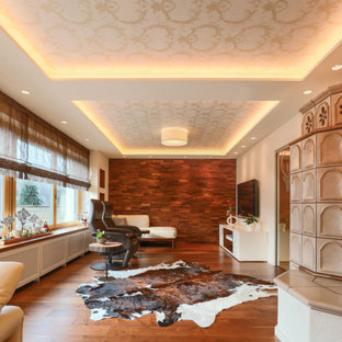 Großes, Abgetrenntes Mediterranes Wohnzimmer mit weißer Wandfarbe, braunem Holzboden, Wand-TV und braunem Boden in Köln